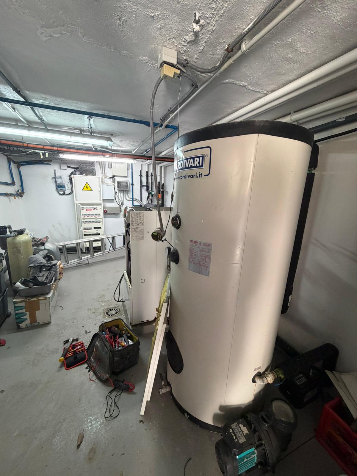 Wide plant room view showing Cordivari hot water cylinder, electrical distribution board, and equipment