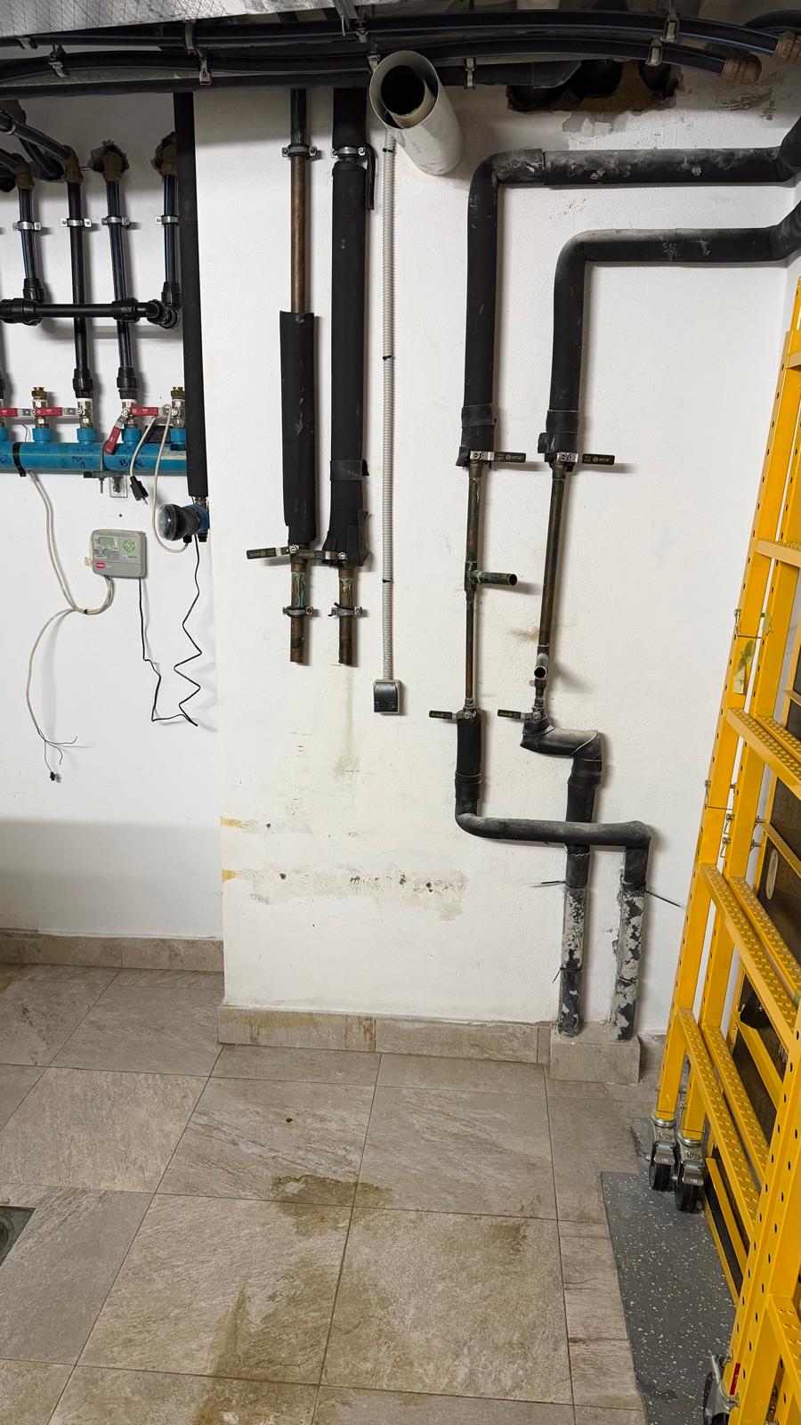 New black insulated pipework installed in La Cala de Mijas plant room — blue hydraulic manifold, zone valves and controller wiring after removal of oil boiler by Agua Therm