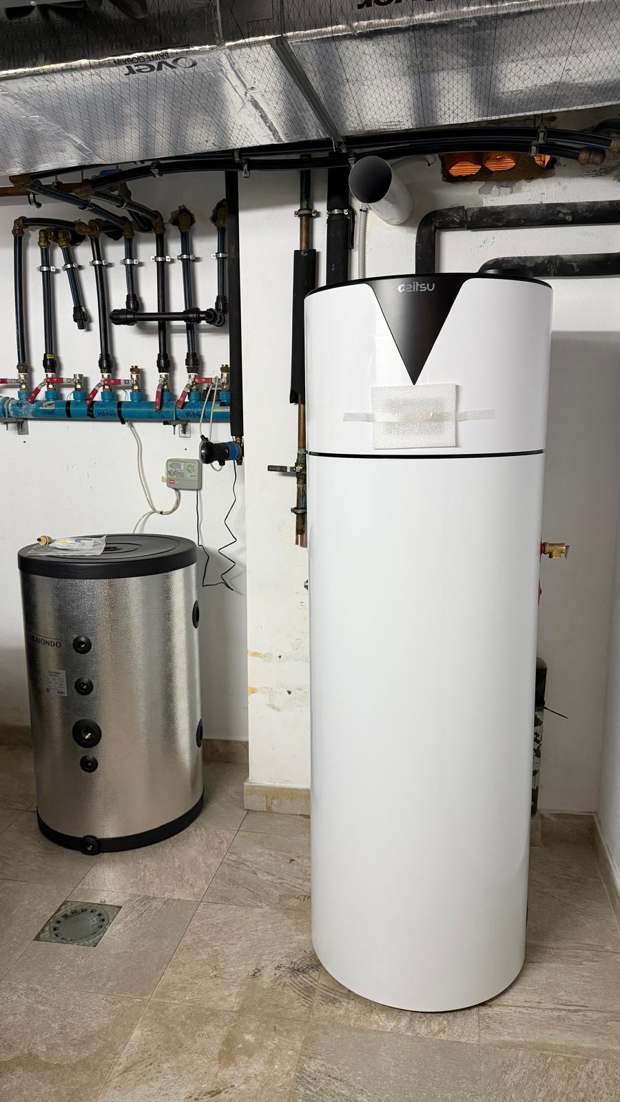 Daitsu aerothermal heat pump installed in La Cala de Mijas plant room alongside stainless steel buffer cylinder and blue hydraulic manifold — installation completed by Agua Therm Costa del Sol