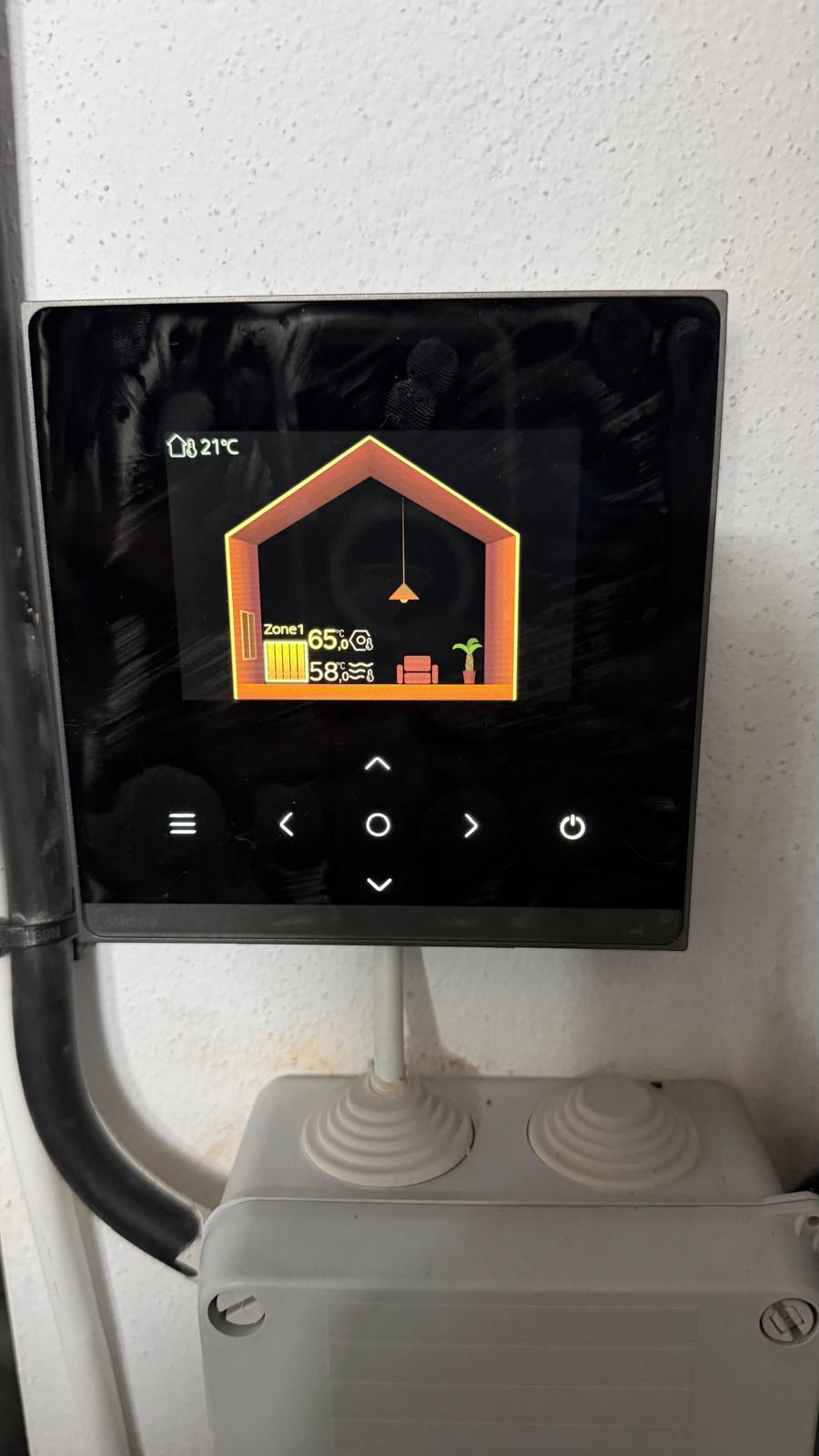 Smart heating system thermostat in La Cala de Mijas showing ambient temperature 21°C, Zone 1 active at 65% with 58% humidity — Midea/Daitsu heat pump system live and running