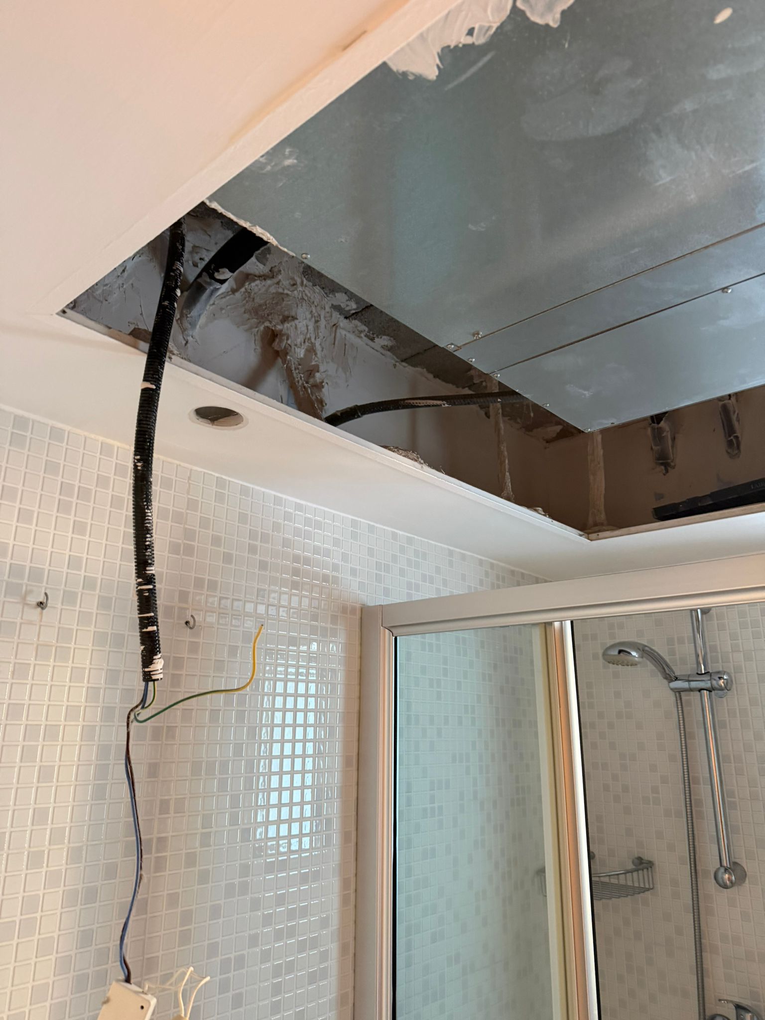 Ceiling void open showing old Daikin copper lineset before removal