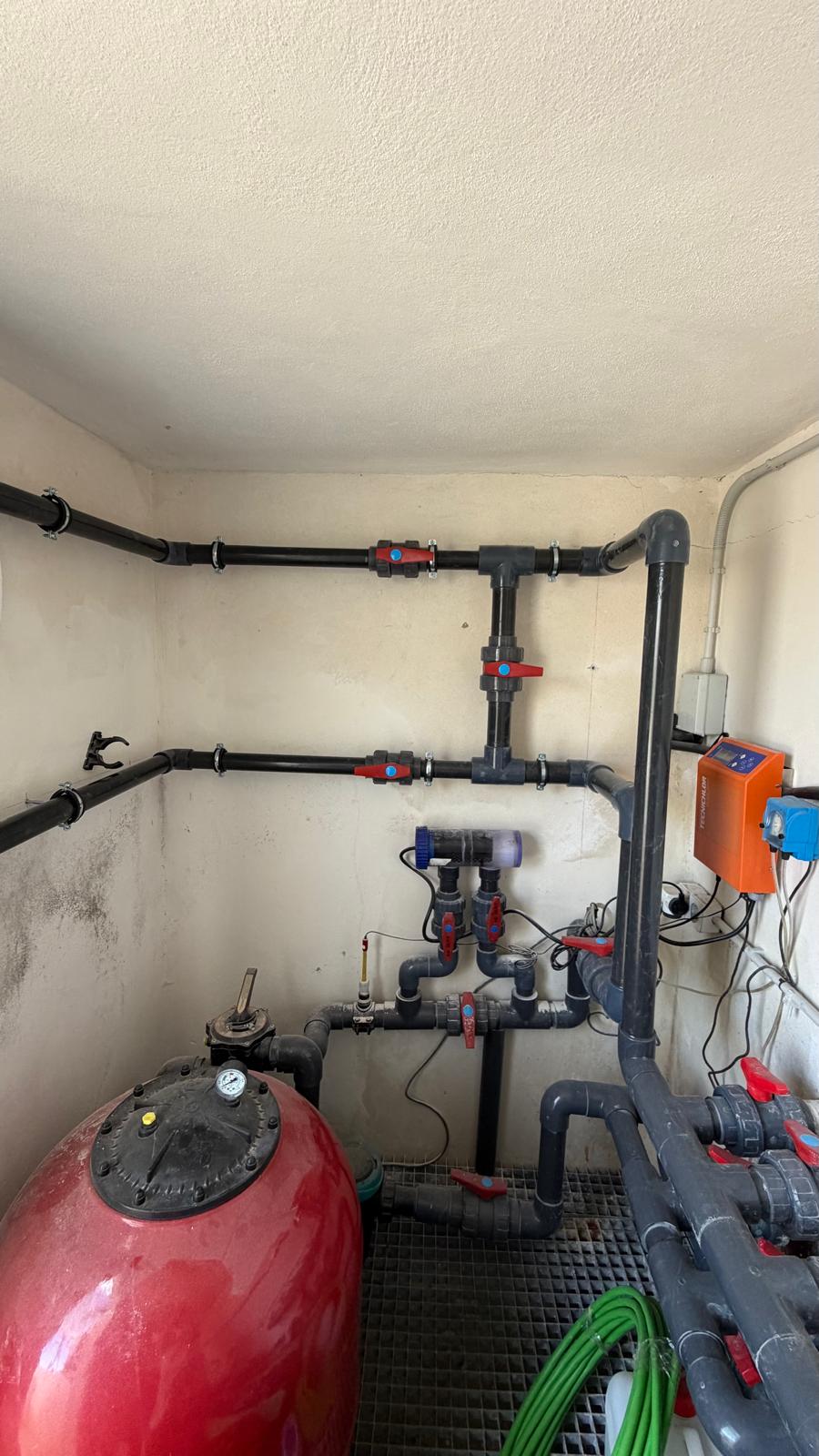Wide view of plant room with red sand filter and new heater bypass