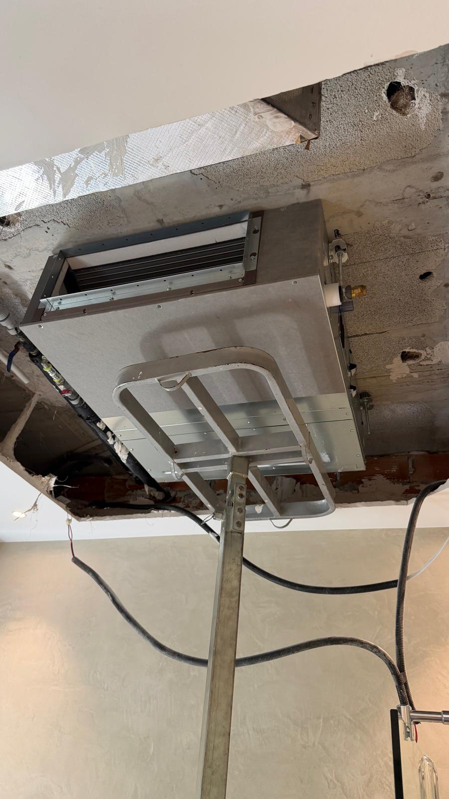 Vista inferior de la unidad interior Daikin instalada en plenum — bandeja de condensados nivelada