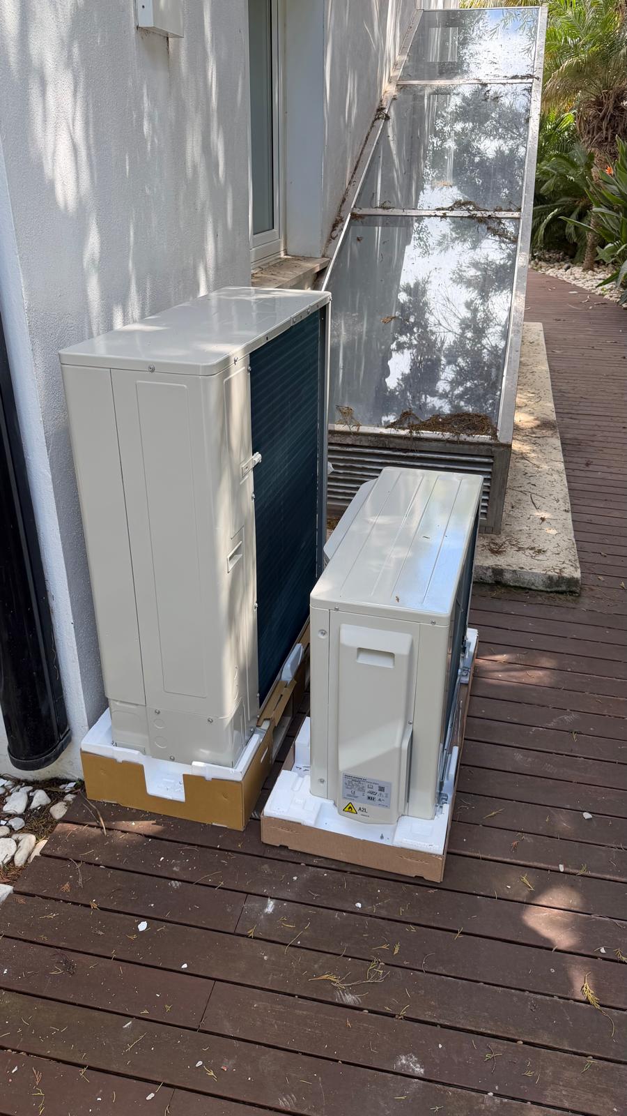 Dos unidades exteriores Daikin R32 inverter en terraza lateral con tarima de madera — etiqueta A2L visible