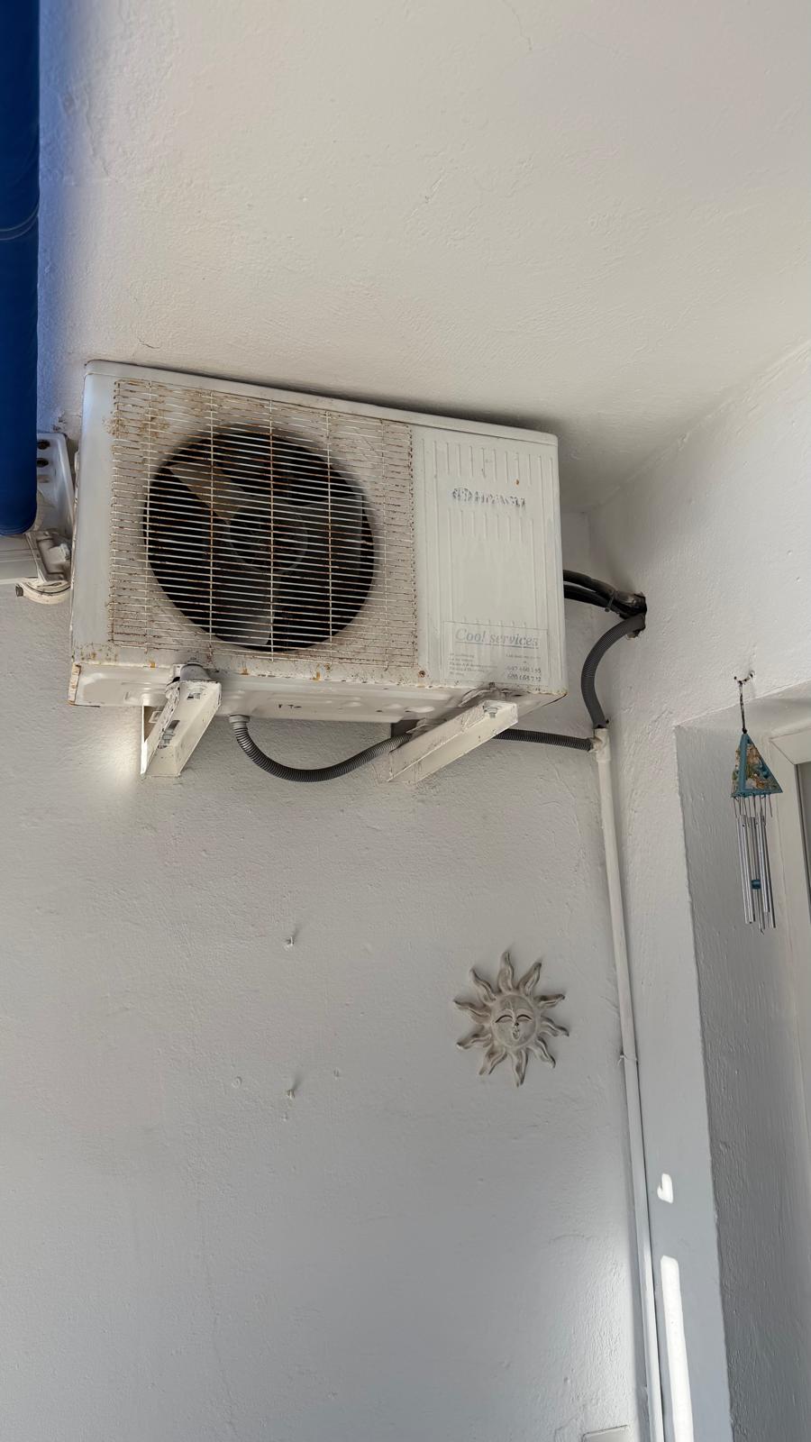 Old yellowed end-of-life Fujitsu split AC indoor unit before replacement in Torremolinos apartment