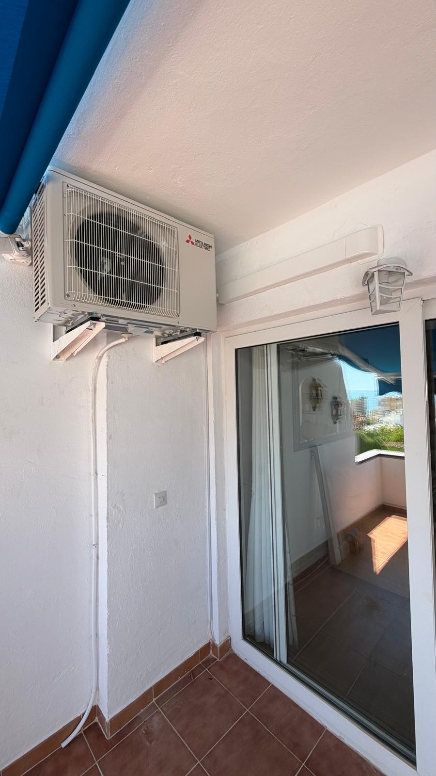 Installed Mitsubishi Electric MUZ-HR50VF2 outdoor AC unit on Torremolinos apartment balcony, wide shot