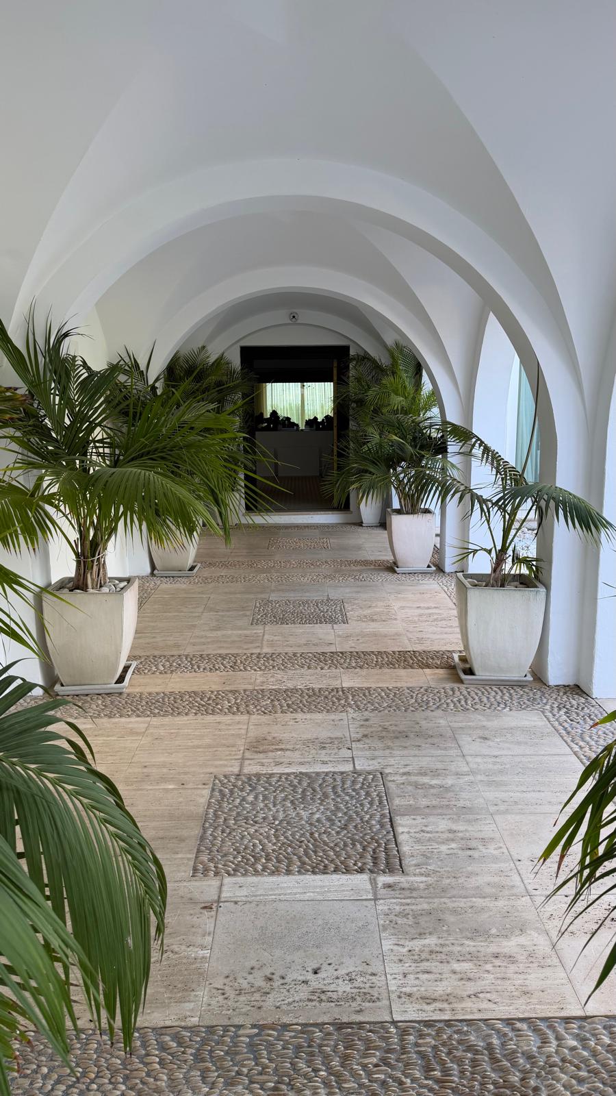 La columnata abovedada de la villa con suelo de canto rodado — el mismo interior con arcos donde se entregó el equipo Daikin, confirmando una única propiedad.