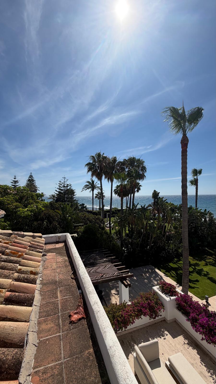 Terraza en la cubierta con vistas sobre los jardines hasta el mar — el tipo de propiedad donde una climatización silenciosa y eficiente importa.