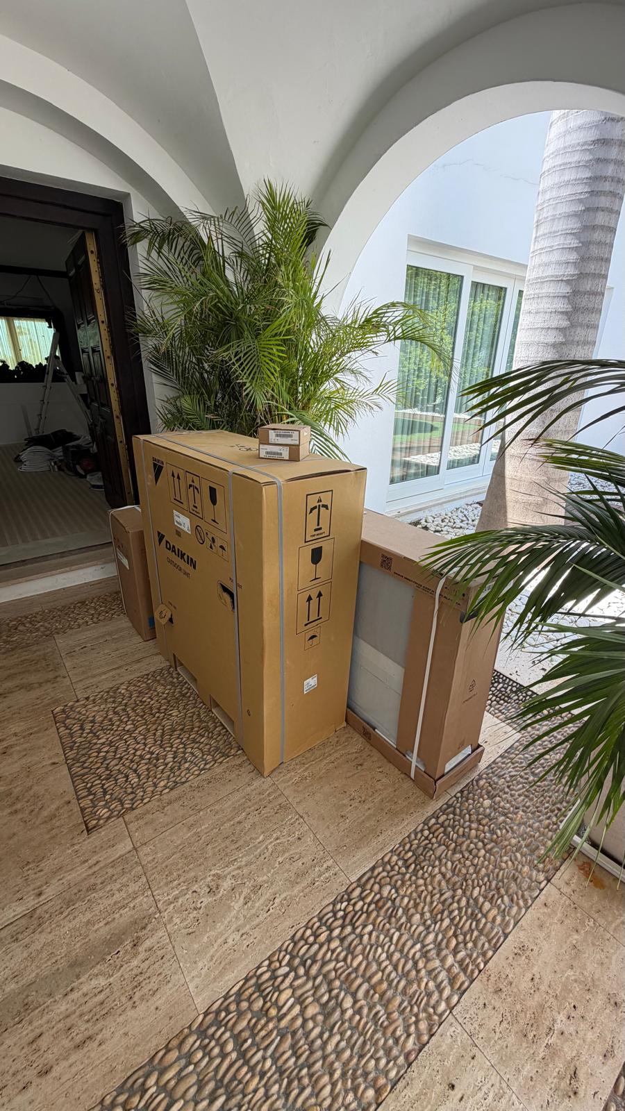 Equipos de aire acondicionado Daikin entregados en el zaguán abovedado de la villa, listos para su instalación.